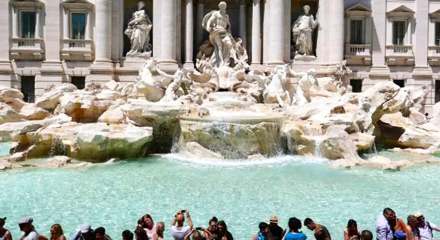 A tourist is seen climbing into the Trevi Fountain in Rome to refill her water bottle in a viral video.