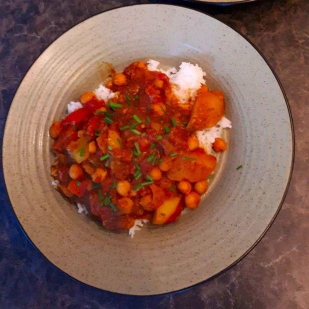 Cover Image for Alicia's version of Aloo Gobi offers a delightful variation of this traditional Indian dish, featuring potatoes and cauliflower in a savory coconut milk sauce, enhanced with aromatic spices and hearty chickpeas.